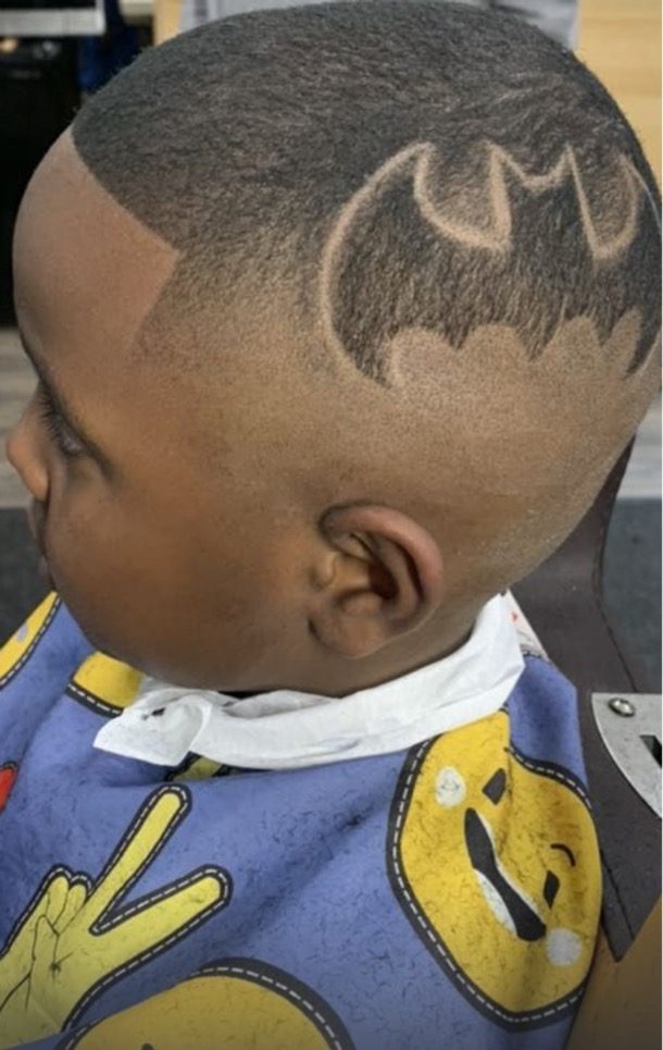 Kids cut with a freehand bat hair design and a skin fade